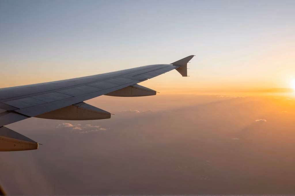 Vue aérienne d'une aile d'avion au coucher du soleil pour un voyage serein et assuré